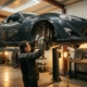 Mechanic examining coilover shock absorber on car's undercarriage in professional auto garage with hydraulic lift