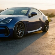 Lowered sports car with coilover suspension showcasing aggressive stance and tucked wheels on asphalt during golden hour
