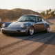 Lowered sports car with chrome wheels on asphalt road, shot from low angle in golden hour lighting with dramatic shadows.