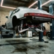 Silver Porsche 911 on hydraulic lift in garage showing exposed suspension components and upgraded parts