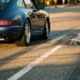 Lowered sports car navigating over speed bump with minimal clearance, chrome exhaust visible, golden hour lighting on asphalt road.
