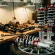 Chrome coilover springs and dampers displayed in professional garage with worn factory suspension parts on workbench