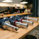 BMW M3 coilover suspension system with silver dampers and red adjustment rings on garage workbench under warm lighting