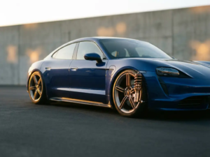 Modern electric car with lowered custom suspension and performance springs on asphalt during golden hour lighting