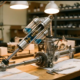 Cutaway shock absorber showing internal damping components connected to precision steering rack on workshop bench with warm lighting